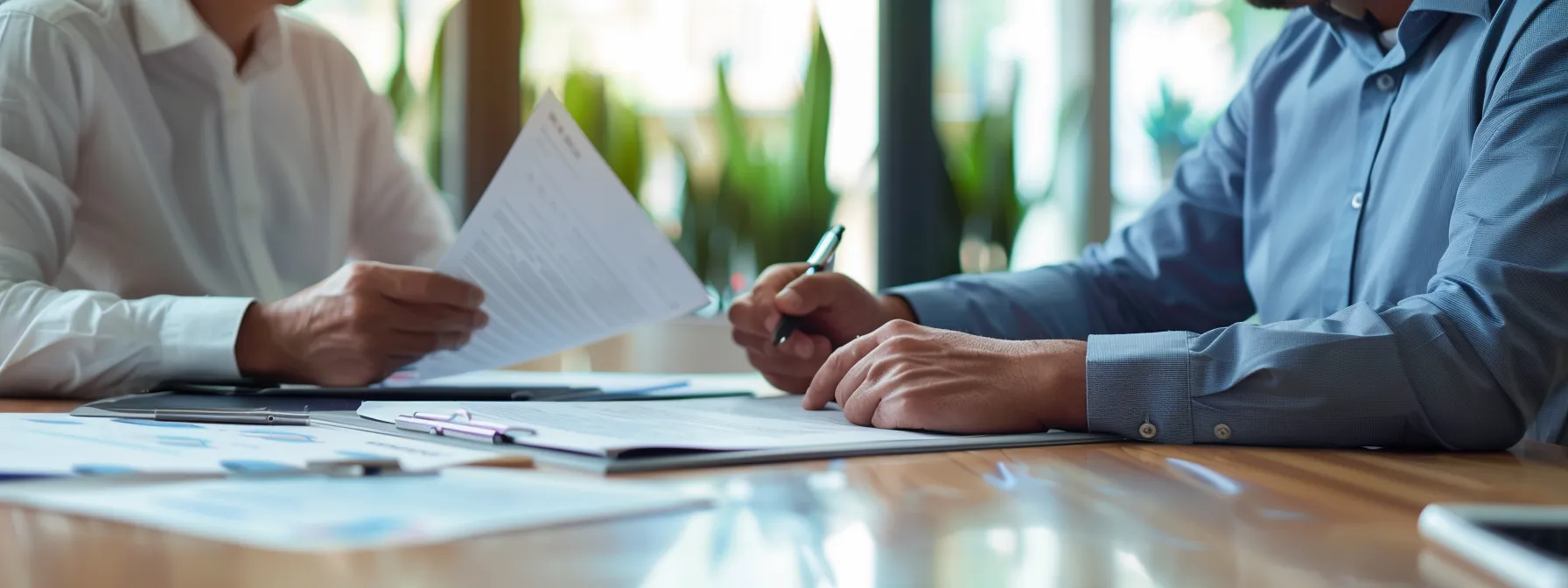 two business professionals engaged in a focused discussion at a conference table, analyzing legal documents.